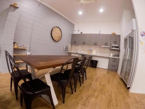 a dining room with a wooden table and chairs at Bunk Inn Hostel in Bundaberg