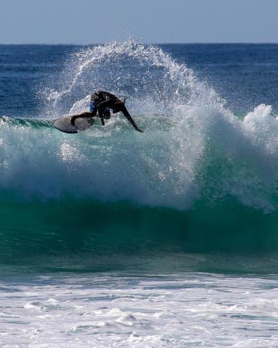 a person riding a wave on a surfboard in the ocean at Cerritos Surf Town - Beach Front Property in El Pescadero
