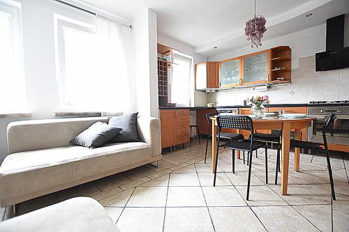 a living room with a couch and a table at Mhost Bronowice in Kraków