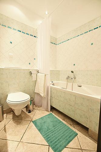 a bathroom with a toilet and a tub and a sink at Mhost Bronowice in Kraków