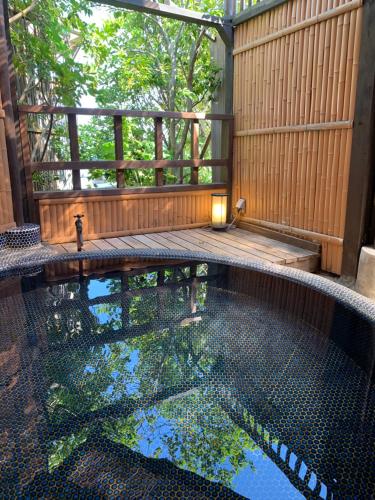 a swimming pool in the middle of a wooden deck at Izu atagawa Yubana mankai -Adult Only- in Higashiizu
