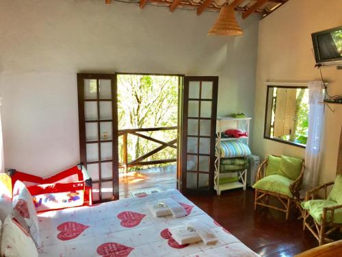 a bedroom with a bed and a tv in a room at Pousada Recanto da Siriema in Monte Alegre do Sul