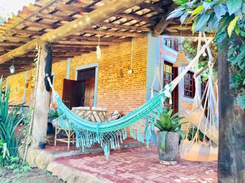 a hammock on the porch of a house at Pousada Recanto da Siriema in Monte Alegre do Sul