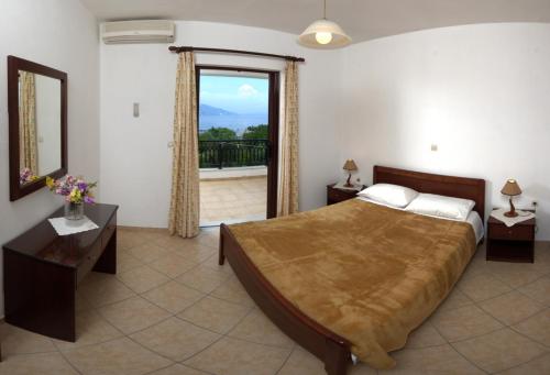 1 dormitorio con 1 cama grande y balcón en Marialice, en Dassia