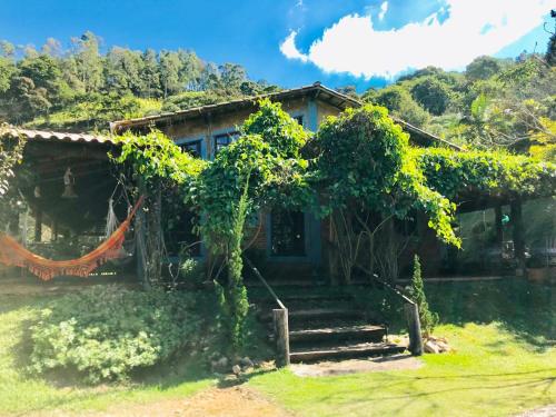a house with a bunch of vines growing around it at Pousada Recanto da Siriema in Monte Alegre do Sul