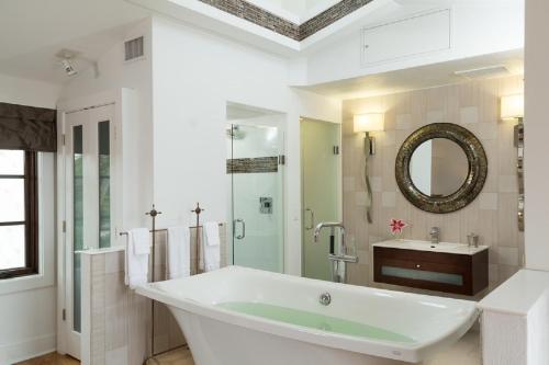 un bagno bianco con vasca e lavandino di Black Dolphin Inn a New Smyrna Beach
