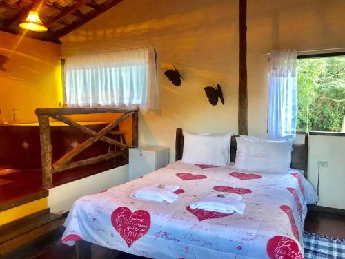 a bedroom with a bed with hearts on it at Pousada Recanto da Siriema in Monte Alegre do Sul