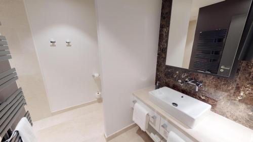 ein Badezimmer mit Waschbecken und Spiegel in der Unterkunft White Pearl Apartment 0.11 in Timmendorfer Strand