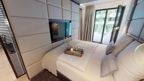 Zimmer mit einem Bett, einem TV und einem Sofa in der Unterkunft White Pearl Apartment 0.11 in Timmendorfer Strand