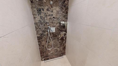 a bathroom with a shower with a hose on the wall at White Pearl Apartment 1.10 in Timmendorfer Strand
