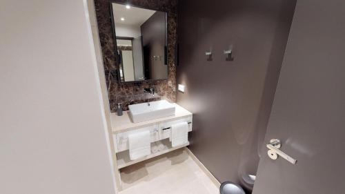 White Pearl Apartment 0.10 في تيميندورفير ستراند: حمام مع حوض ومرآة