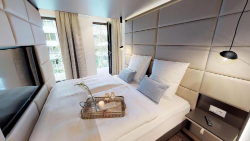 ティメンドルファー・シュトラントにあるWhite Pearl Apartment 1.13の白いベッド1台(バスケット付)が備わるベッドルーム1室が備わります。
