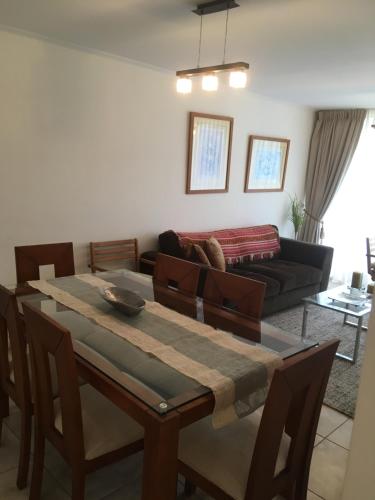 a living room with a table and a couch at Departamento Costa Peñuelas in Coquimbo