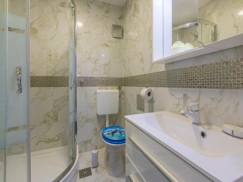 a bathroom with a sink and a shower and a toilet at Apartment Cherry 2 in Selce