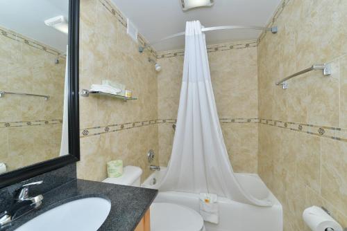 a bathroom with a shower and a sink and a tub at Days Inn by Wyndham Washington DC/Connecticut Avenue in Washington, D.C.