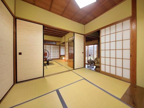 an empty room with white doors and a room with a table at Kaike Fuga in Yonago