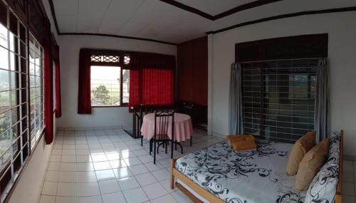 a living room with a bed and a table in it at Villa Oma Bougenville 2 in Puncak