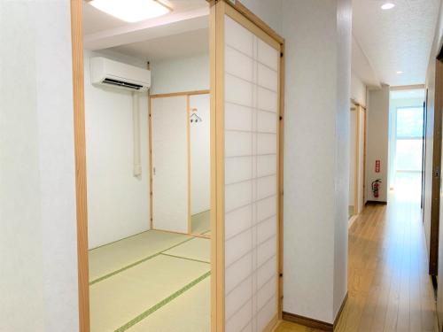 ein Ankleidezimmer mit Spiegel und ein Flur in der Unterkunft “Okawa Stay” Five-Bedroom Condo in Ishigaki-jima