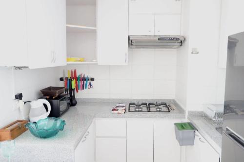 a white kitchen with a stove and white cabinets at Valemar in La Serena
