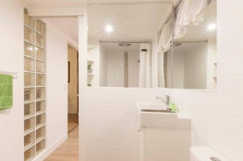 uma casa de banho branca com um lavatório e um espelho em Funky, Central Studio em Noosa Heads