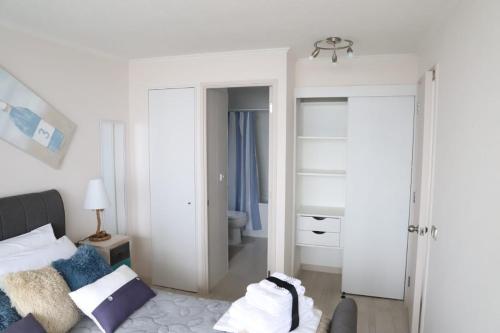 a white room with a bed and a bathroom at Valemar in La Serena