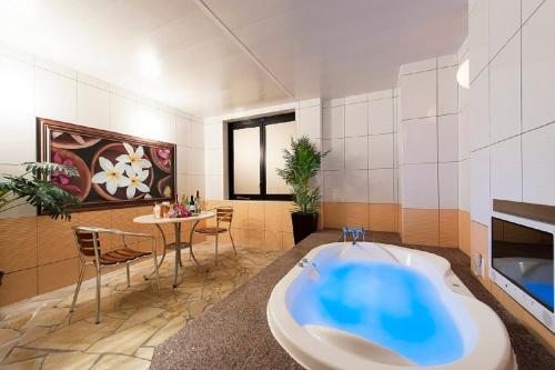 Ginan的住宿－岐阜礦山情趣酒店（僅限成人），带浴缸和桌椅的浴室