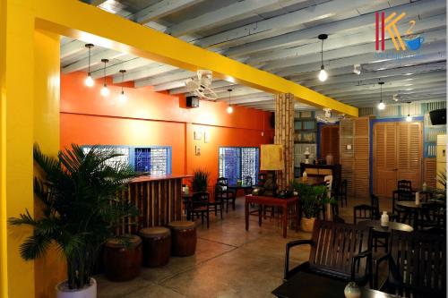a restaurant with tables and chairs and a yellow wall at K2 Homestay & Coffee in Can Tho