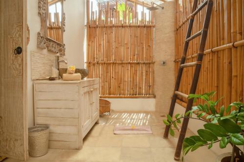 a bathroom with a wooden dresser and a wooden ladder at United Colors of Bali in Canggu