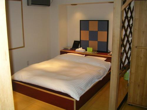 a small bedroom with a bed and a desk at Niseko Youraku Hotel in Niseko