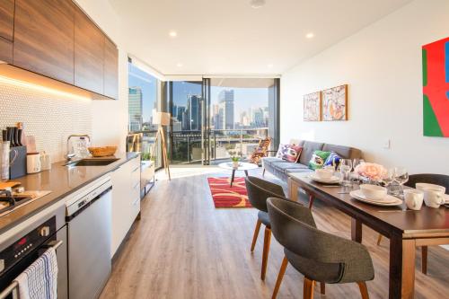 a kitchen and living room with a table and chairs at AirTrip Apartments at South Brisbane in Brisbane