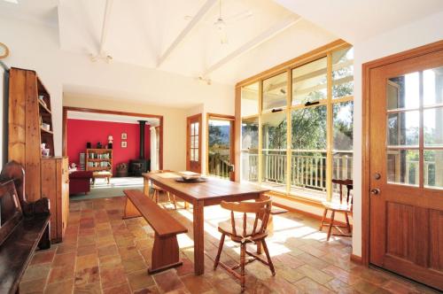 a dining room with a wooden table and chairs at Bonnie Doon Family friendly home in Kangaroo Valley