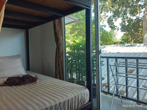 a bedroom with a bed and a balcony at Decho Hostel in Ko Lipe