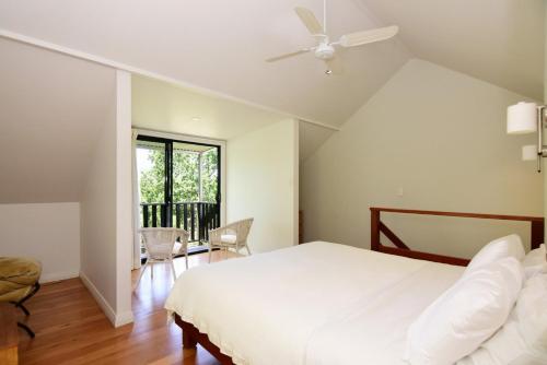 a bedroom with a bed with a ceiling fan at Cloudsong Chalet 4 Close to the village centre in Kangaroo Valley