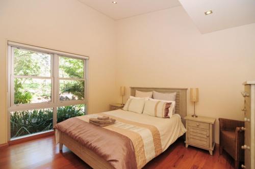 a bedroom with a bed and a large window at Bottlebrush Lodge Great views and a pool in Upper Kangaroo River