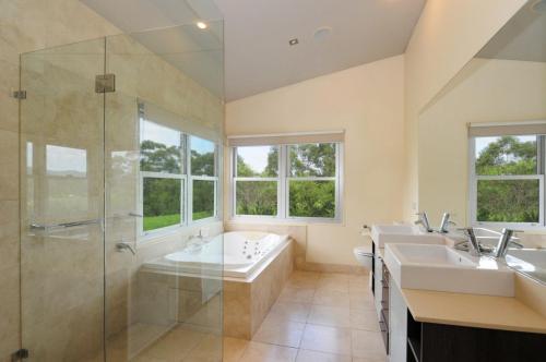 a large bathroom with two sinks and a shower at Bottlebrush Lodge Great views and a pool in Upper Kangaroo River