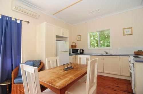 a kitchen with a wooden table and a dining room at Love Shack 1 bedroom cosy cottage in Upper Kangaroo River