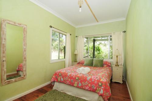 a bedroom with a bed and a mirror at Love Shack 1 bedroom cosy cottage in Upper Kangaroo River