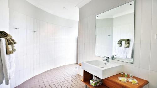 a bathroom with a sink and a mirror at Cloudsong Chalet 4 Close to the village centre in Kangaroo Valley