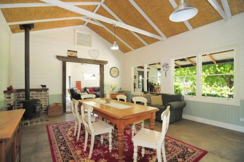 uma sala de estar com uma mesa de madeira e cadeiras em Spring Grove Dairy Picturesque views em Upper Kangaroo River