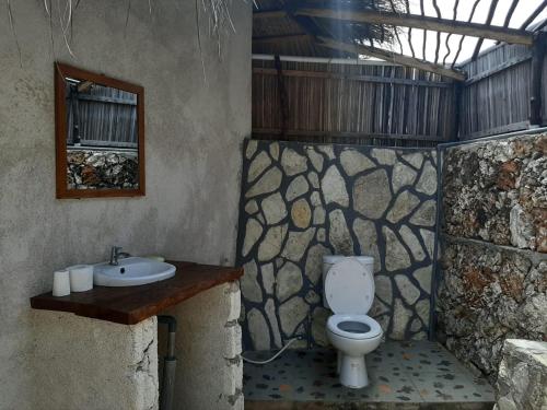bagno con servizi igienici e lavandino di Mulia Bungalows a Nembrala
