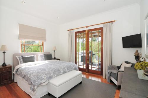 1 dormitorio con cama, sofá y TV en Rivermist Luxury 6 bedrooms and 6 bathrooms en Kangaroo Valley