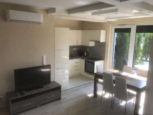 a kitchen with a dining room table and a television at Azur apartman in Balatonfüred
