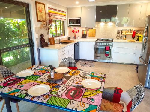 a kitchen with a table with plates on it at Januce - delightful river front house in Urunga in Urunga