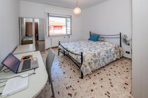 a bedroom with a bed and a desk with a laptop at Bolle blu - By Ligooria in Borgio Verezzi