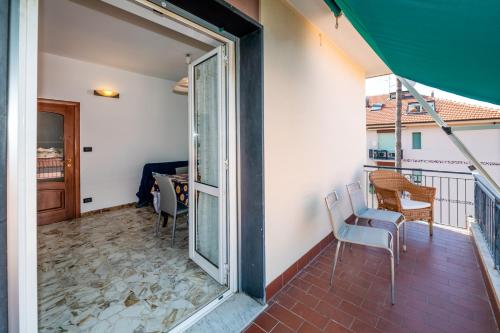 a balcony with a door open to a room with a table and chairs at Bolle blu - By Ligooria in Borgio Verezzi