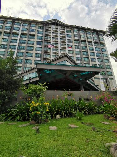 a large building with a garden in front of it at Sabah Oriental Hotel in Kota Kinabalu