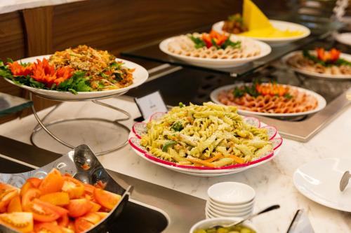 Nha Trang Horizon Hotel في نها ترانغ: بوفيه مع العديد من أطباق الطعام على طاولة