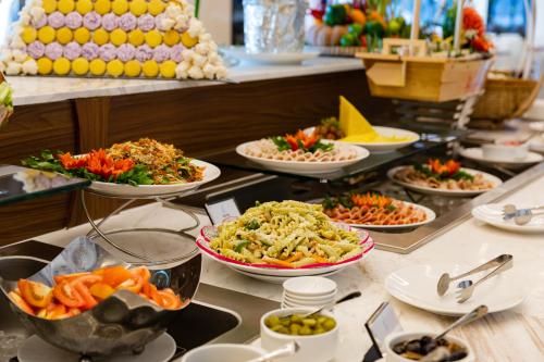 Nha Trang Horizon Hotel في نها ترانغ: بوفيه مع العديد من أطباق الطعام على طاولة