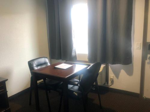 a room with a table and two chairs and a window at Westward Inn in Crescent City