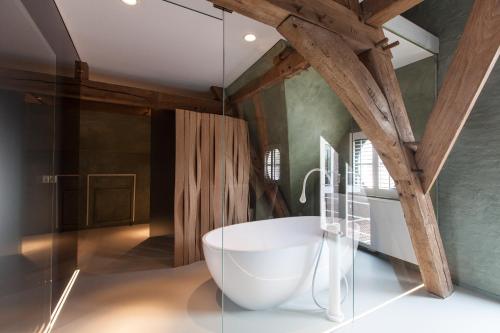 un bagno con una grande vasca bianca in una stanza di B&B La Suite a Bruges